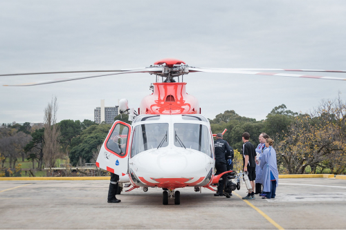 Helicopter on helipad shot from front on with staff unloading a patient