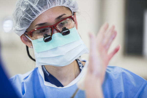 A surgeon performs vascular and plastic surgery to a hand.