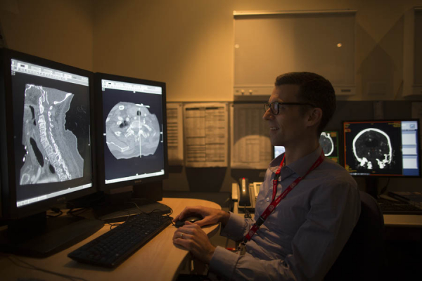 A doctors reviews patient scans.