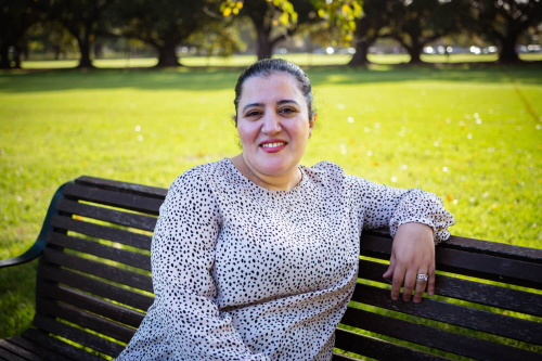 CALD community member sitting on a park bench