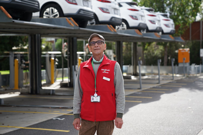Caulfield Hospital volunteer Oscar standing in front of car stacker