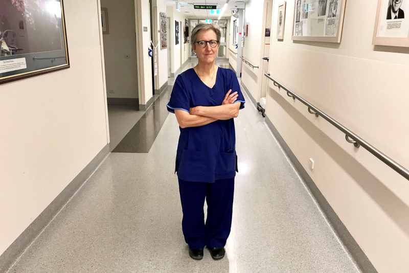 A surgeon stands in the corridor of a hospital ward