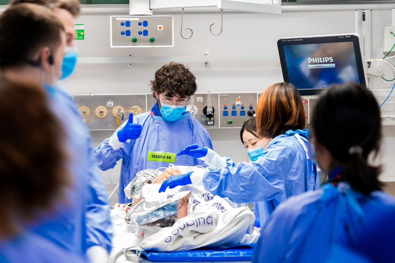 A team of healthcare workers rally around a patient to provide urgent medial care
