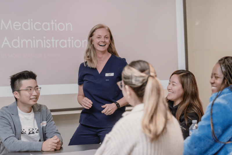 Nurse educator smiling with group of nursing students