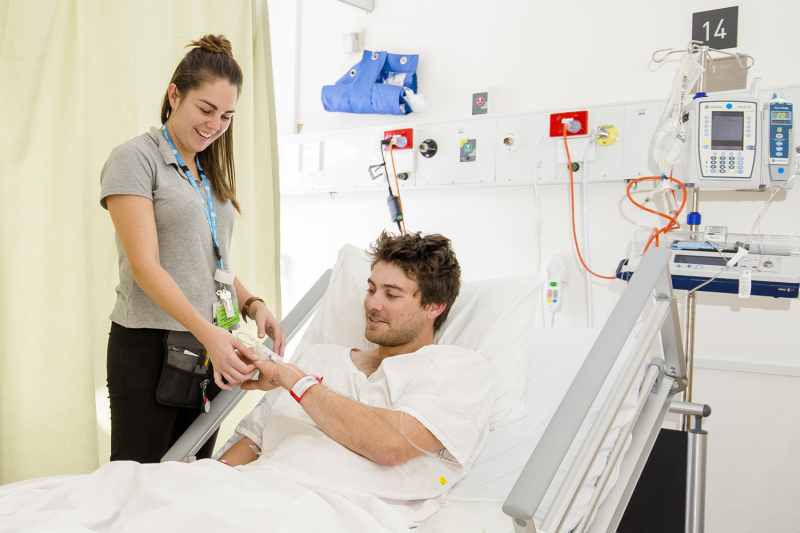 Patient in bed talking to nurse