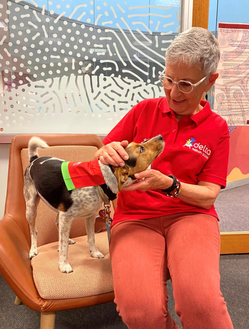 Therapy dog and handler sitting in clinic