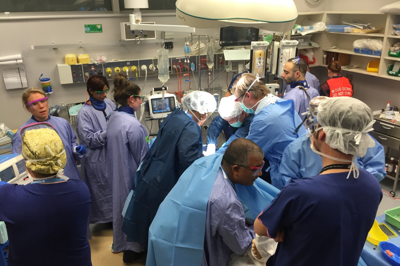 Busy trauma room with many doctors and nurses treating patient