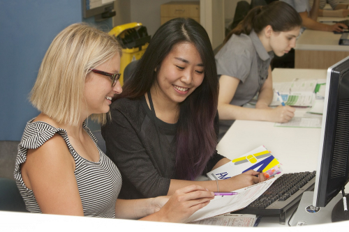 Pharmacists smiling whilst checking a patients medications