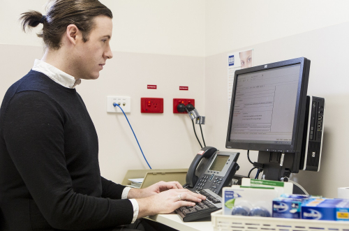 Male staff member sitting at computer doing work