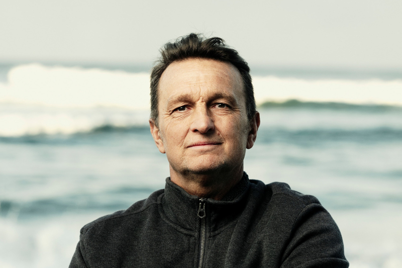 Tim Baker standing on a beach